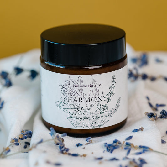 Jar labeled 'Harmony' surrounded by dried lavender on a white fabric background