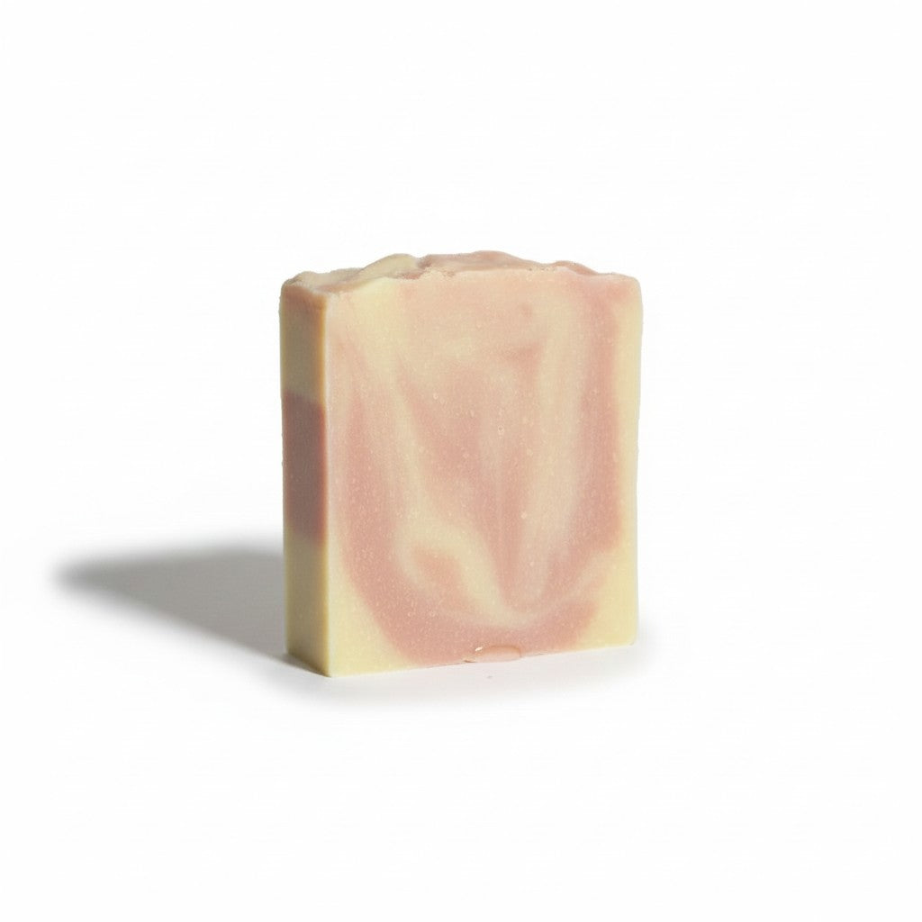Bar of soap with pink and beige swirls on a white background