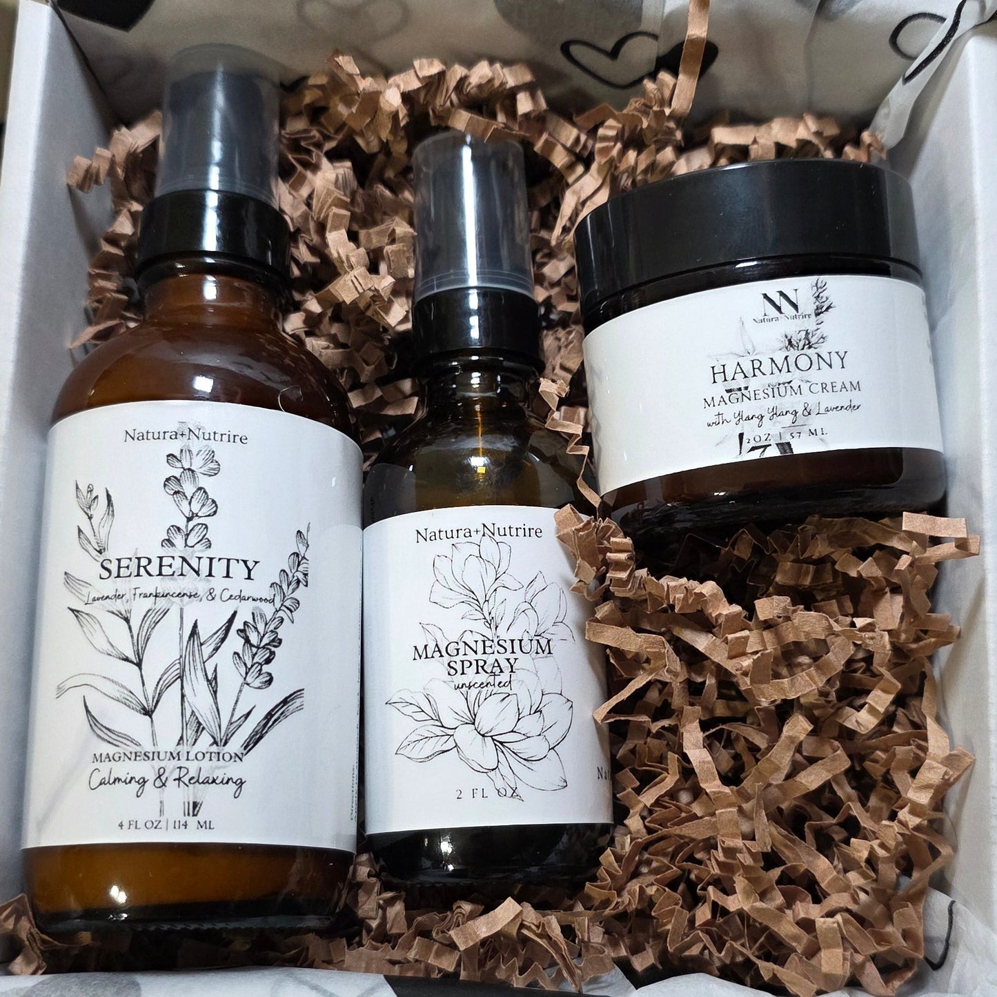 Set of skincare products in a decorative box with heart patterned paper.