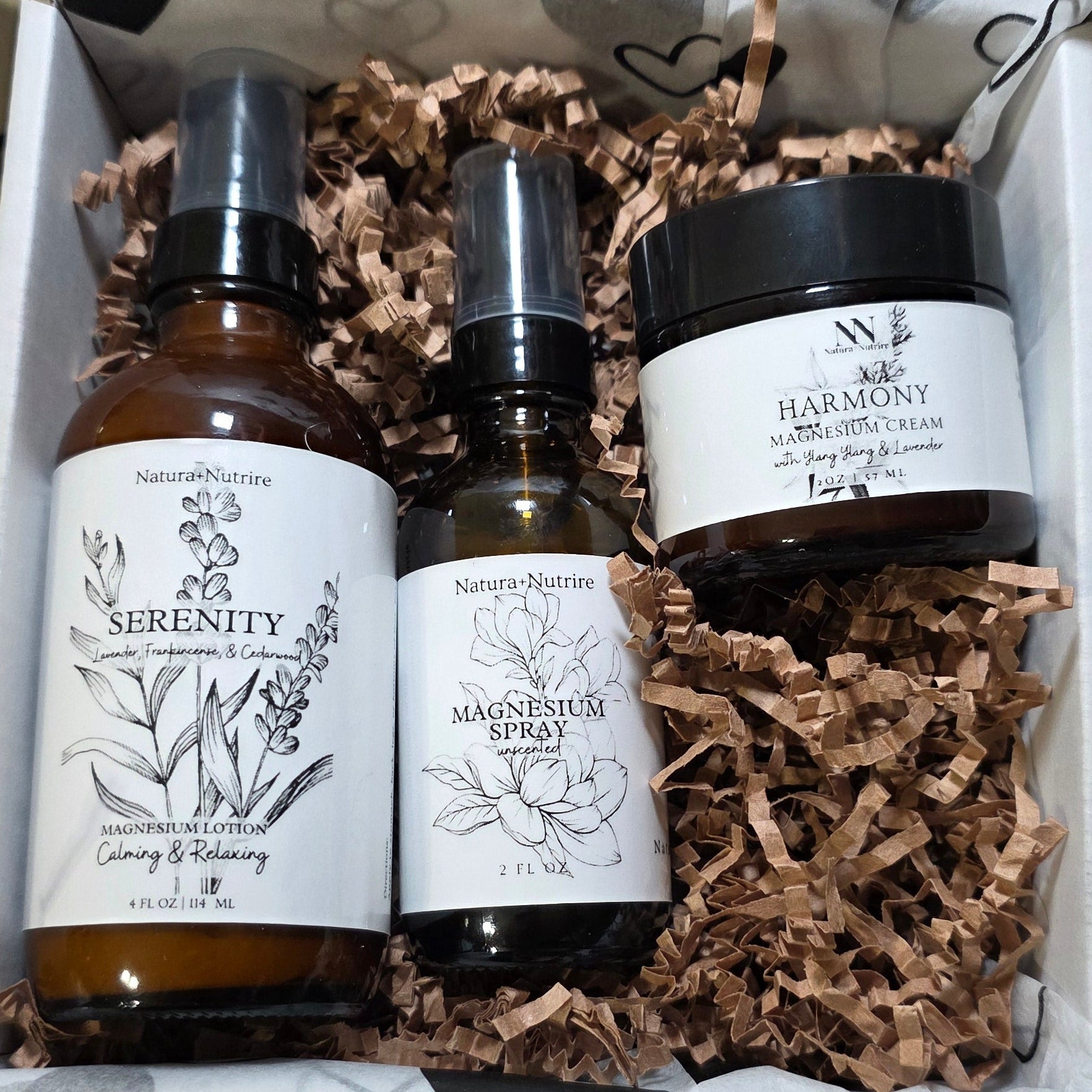 Set of skincare products in a decorative box with heart patterned paper.