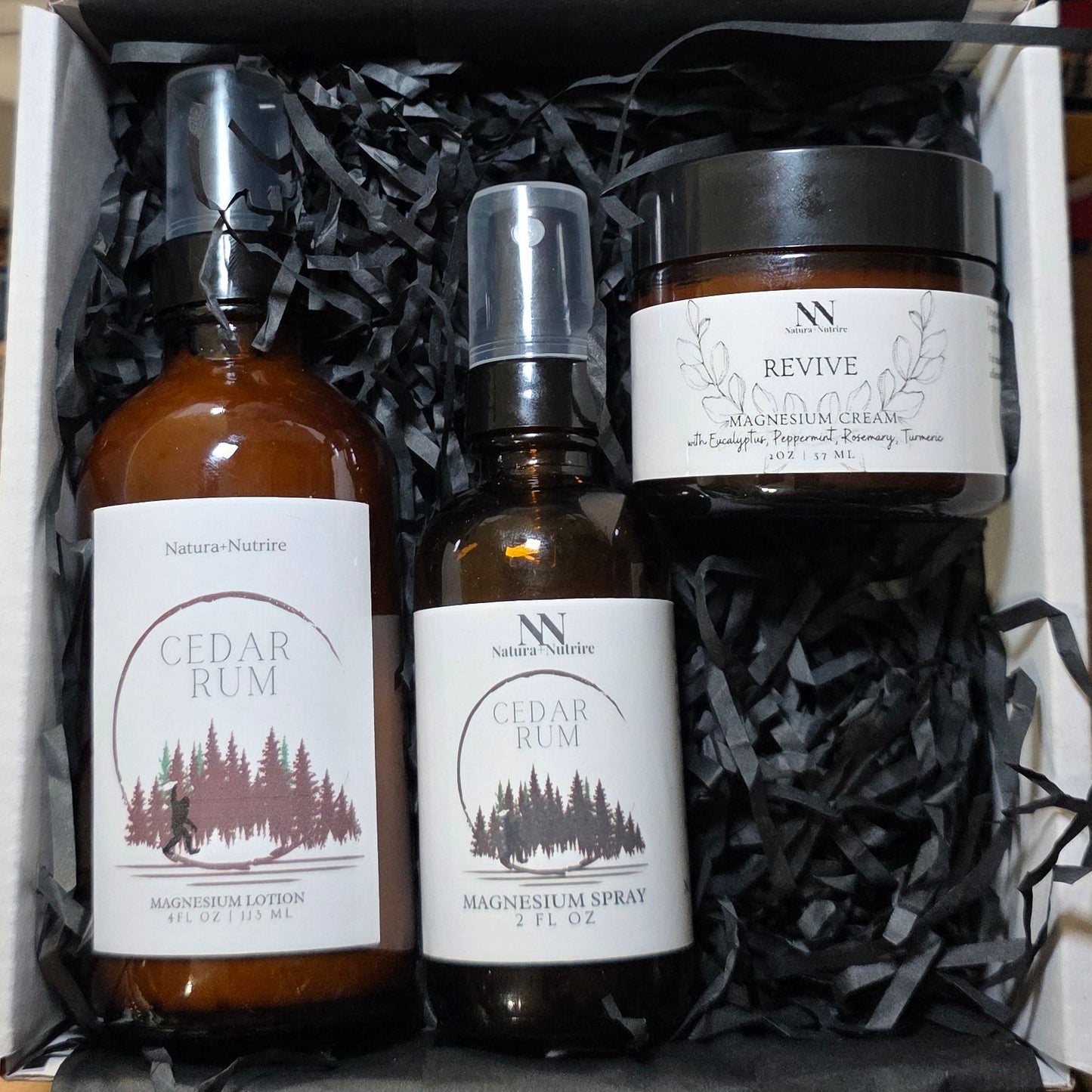 Three bottles with labels in a box on a wooden surface