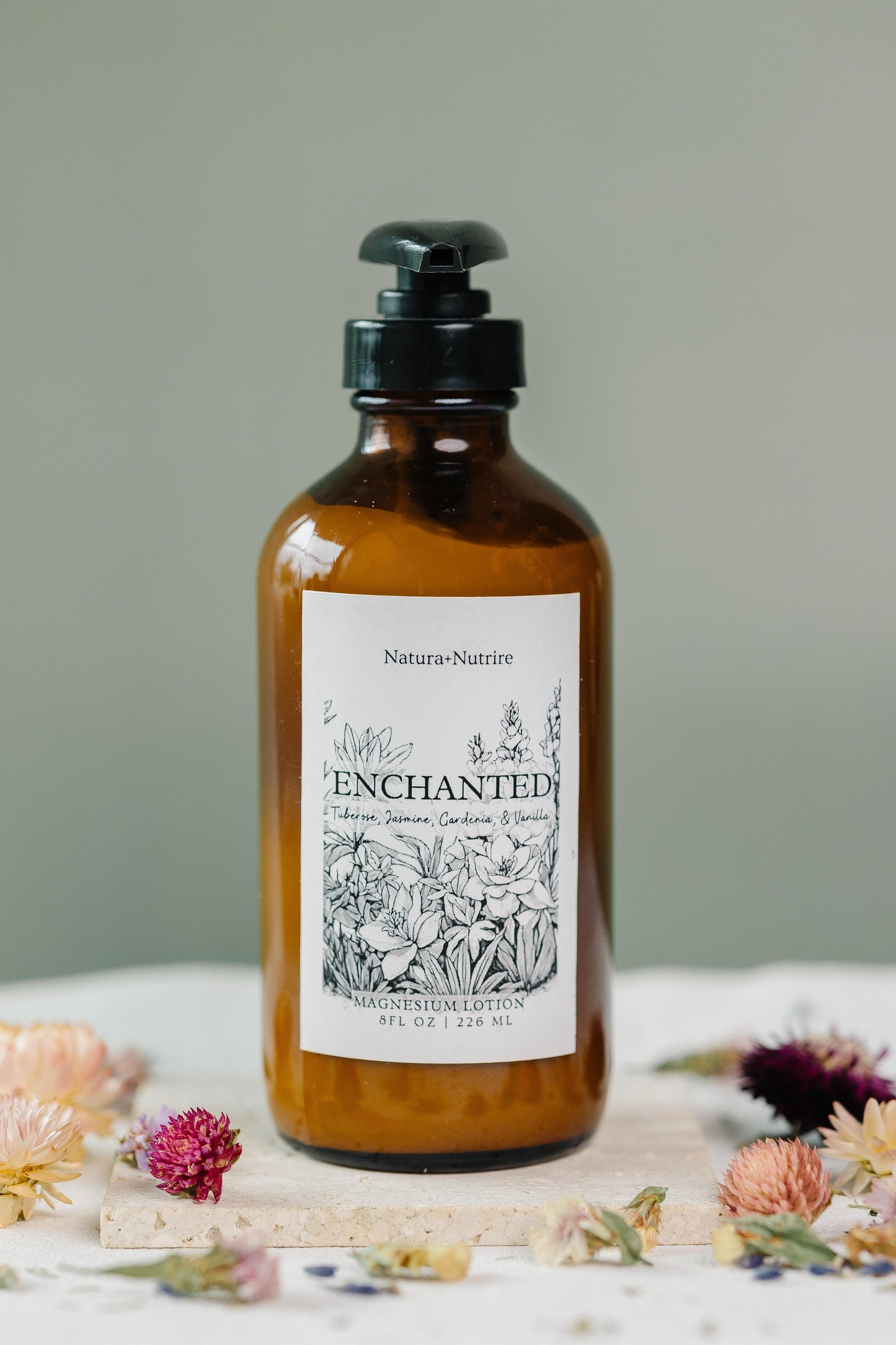 Bottle of 'Enchanted' product with a label on a neutral background