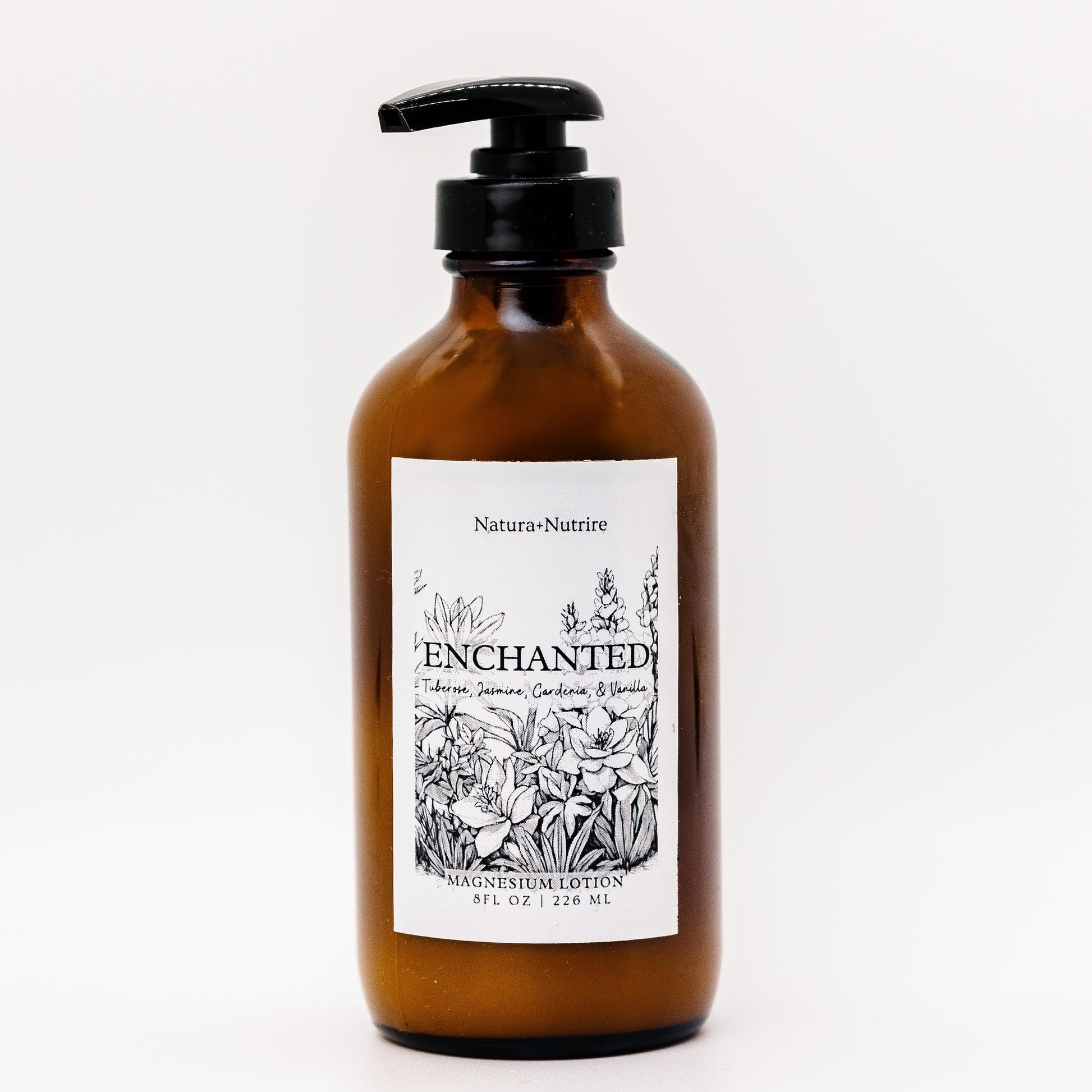 Brown bottle with pump and 'Enchanted' label on a white background