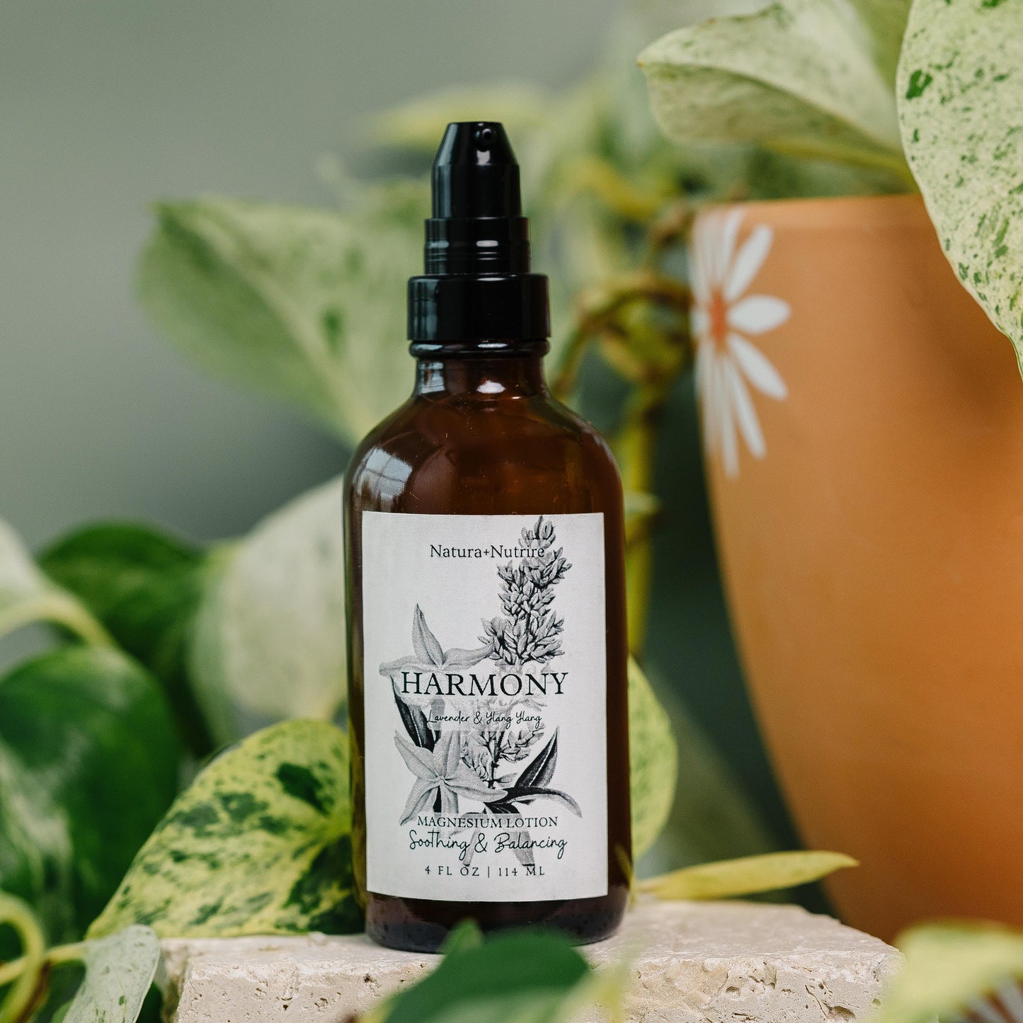 Brown bottle with a label on a surface with green plants in the background