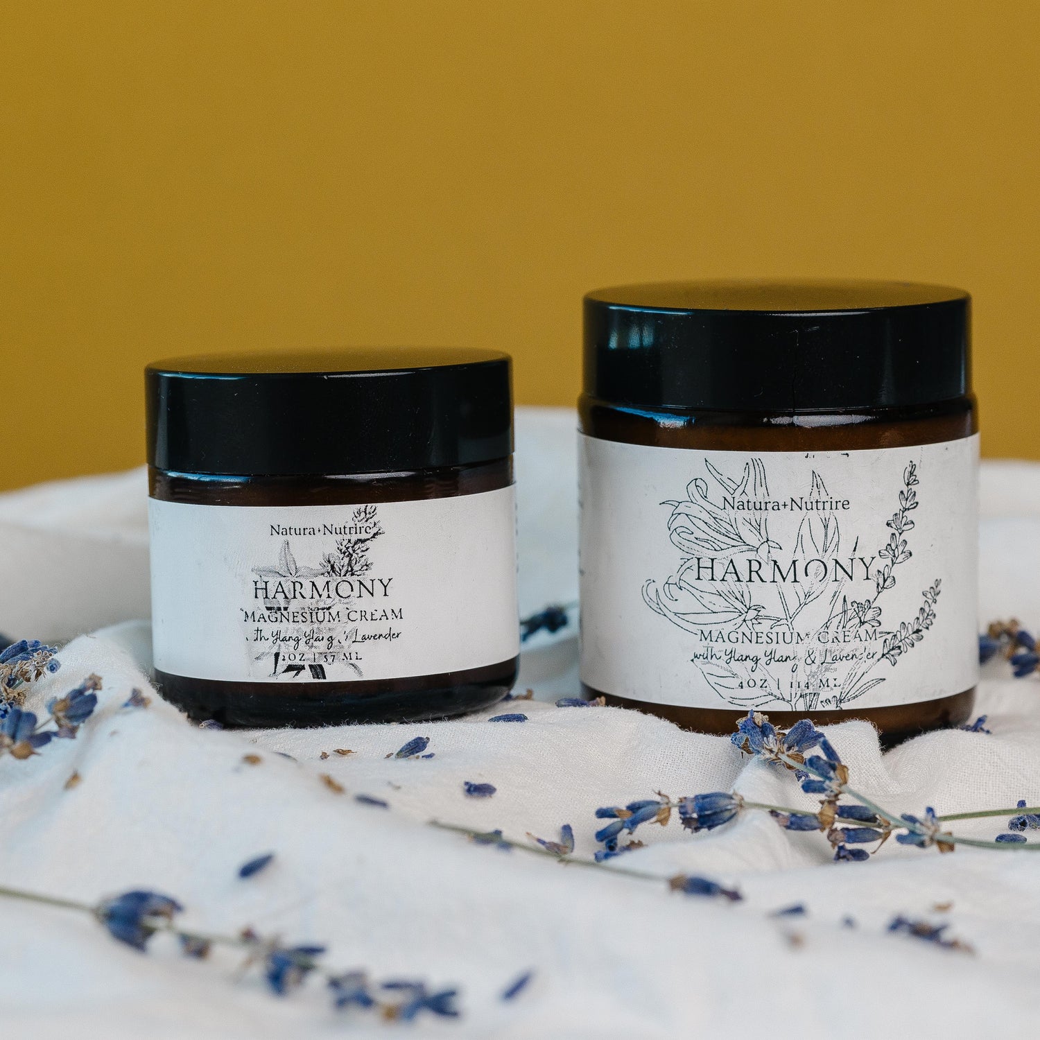 Two jars of 'Harmony' cream on a white surface with lavender flowers, against a yellow background.