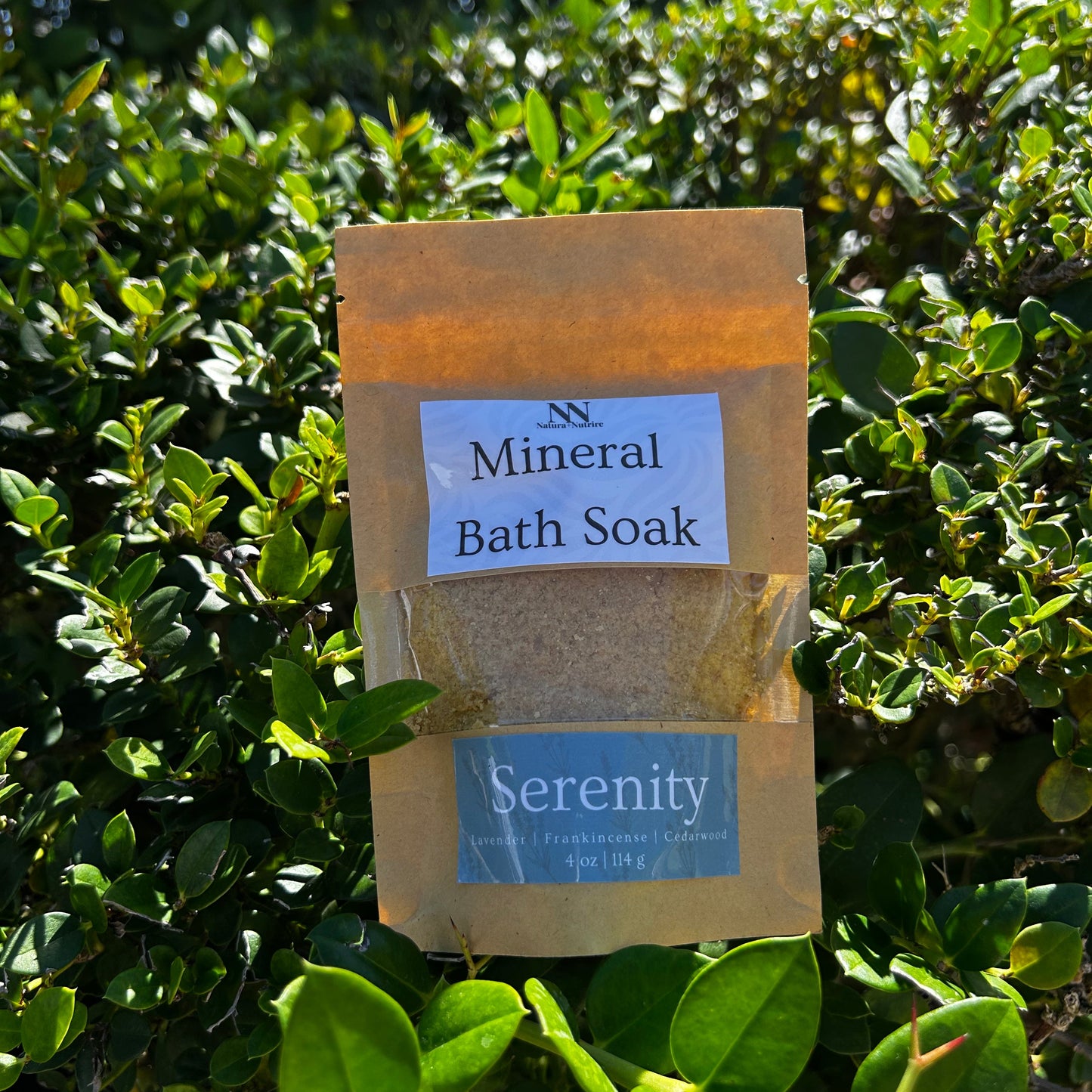 Two packages of 'Mineral Bath Soak' with 'Serenity' label on a green leafy background