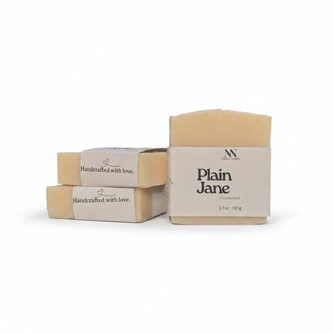 Plain Jane Unscented Handcrafted Soap bars with kraft paper labels, boxed and unboxed, on a white background