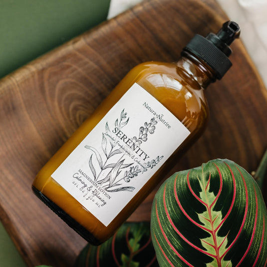 Brown bottle labeled 'Serenity' on a wooden surface with plants in the background