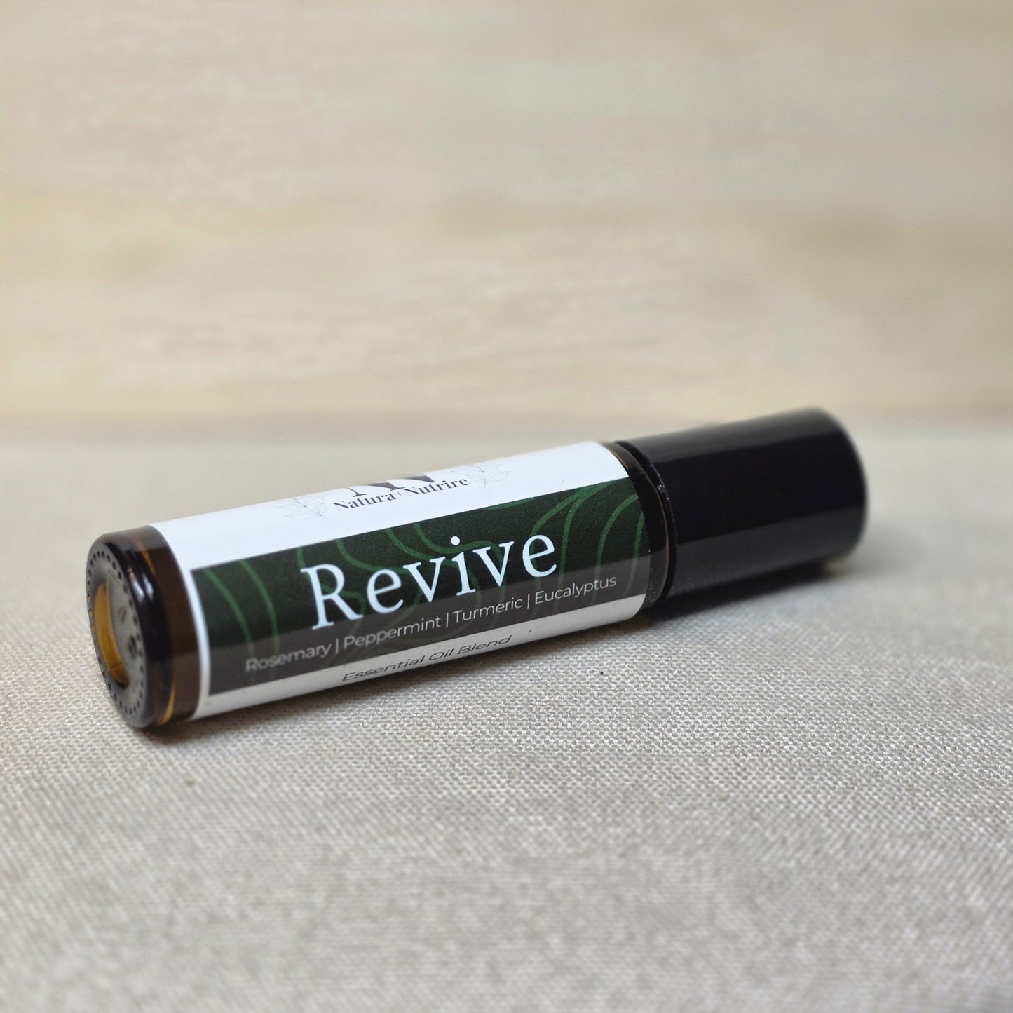 Roll-up bottle labeled 'Revive' on a textured surface