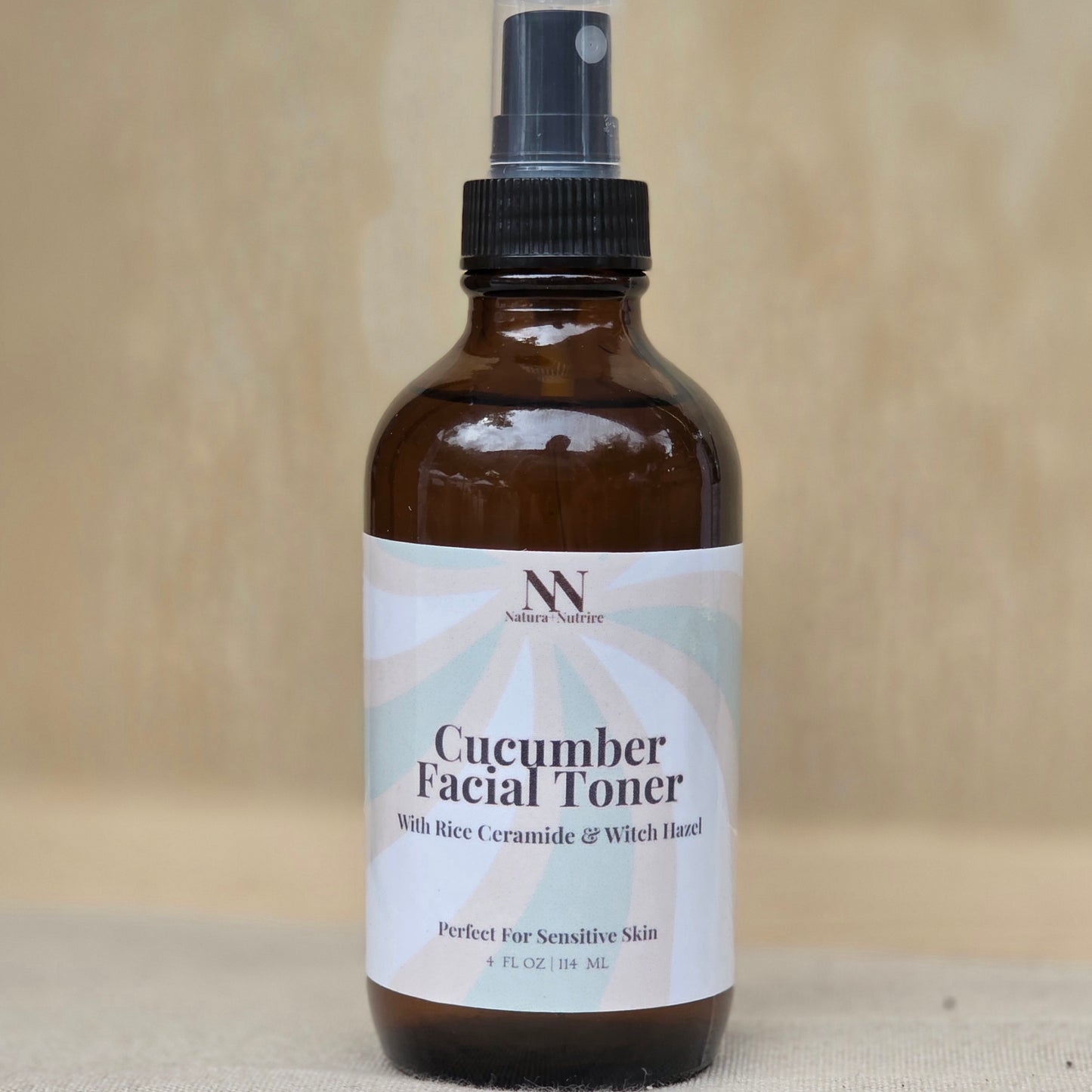 Bottle of cucumber facial toner with a label on a beige background